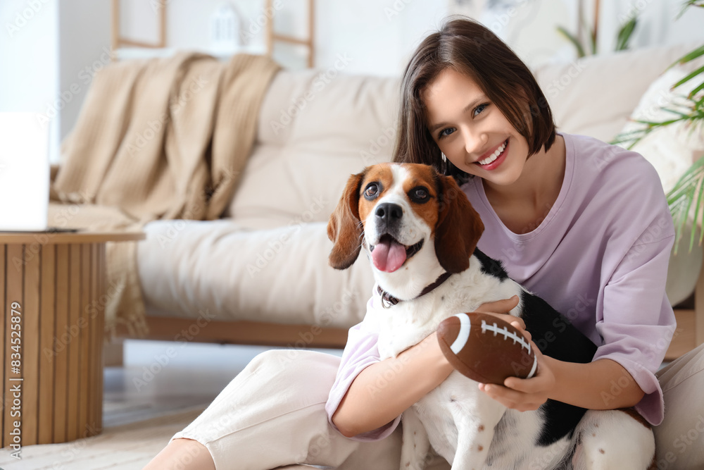 Young woman with ball and Beagle dog at home Young woman with ball and Beagle dog at home