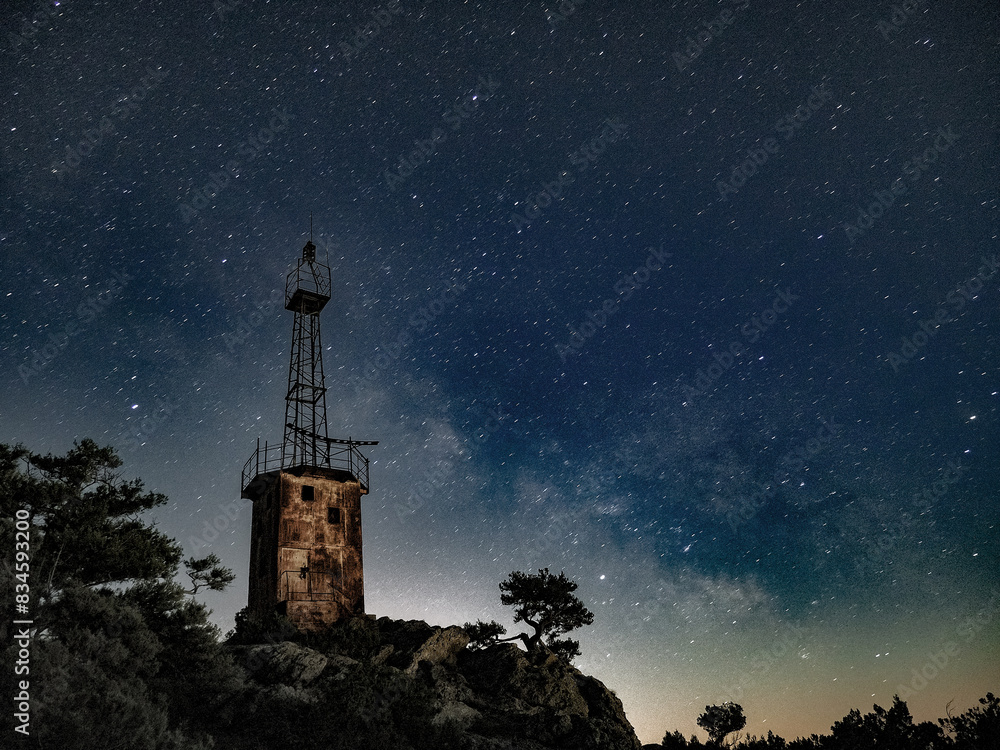 lighthouse under scarry sky at night astrophotography