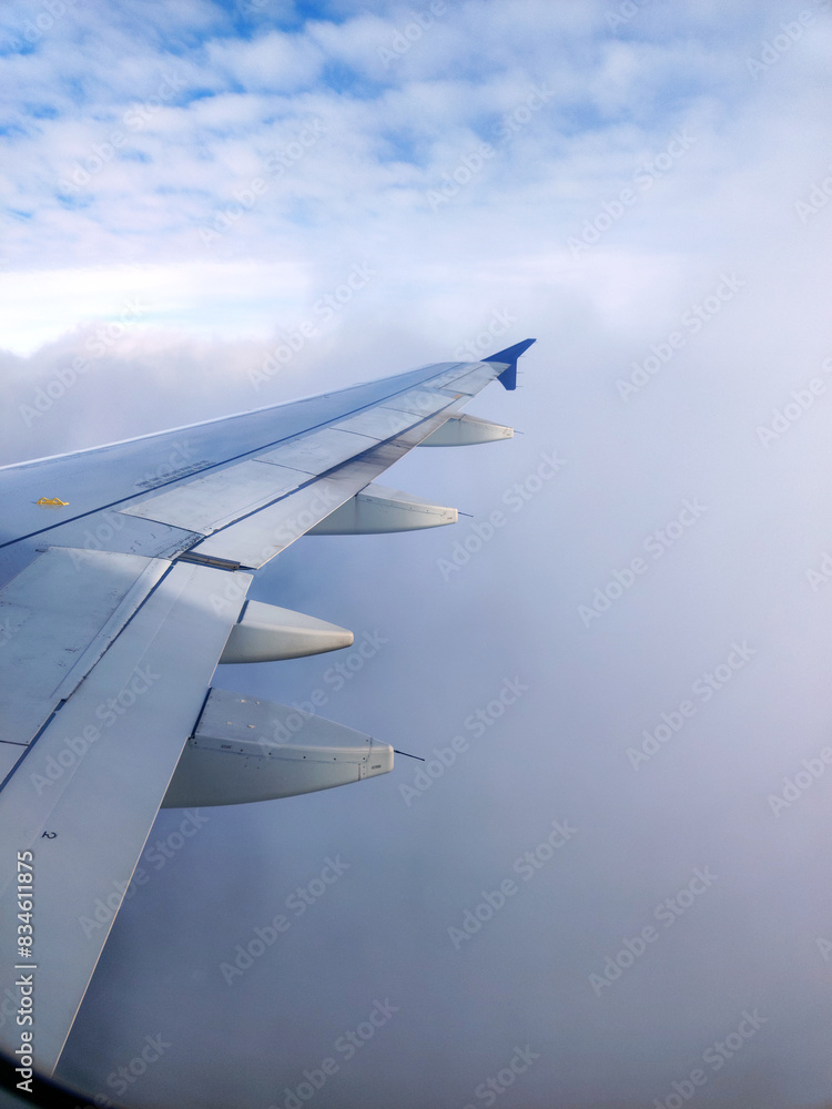 Obraz premium clouds and wing of the airplane seen from the window