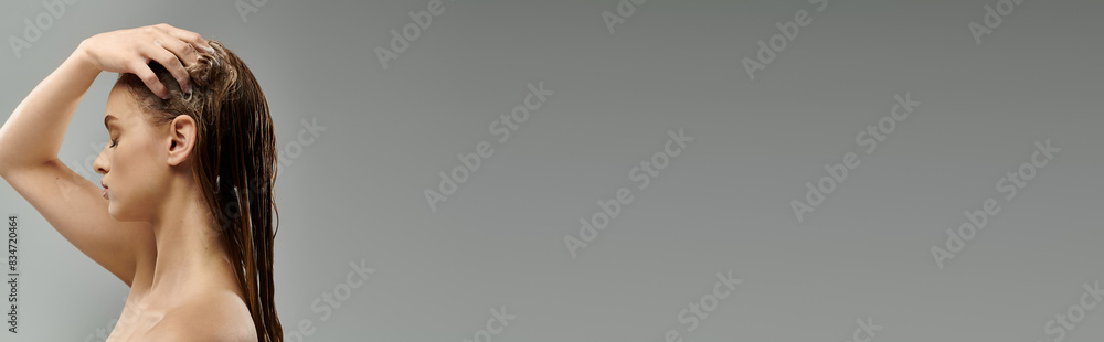 Fototapeta premium Woman with long hair stands gracefully washing hair.