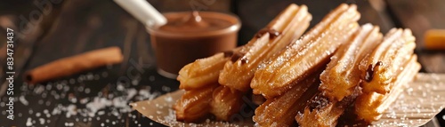 A close-up image of a plate of churros with a side of chocolate sauce