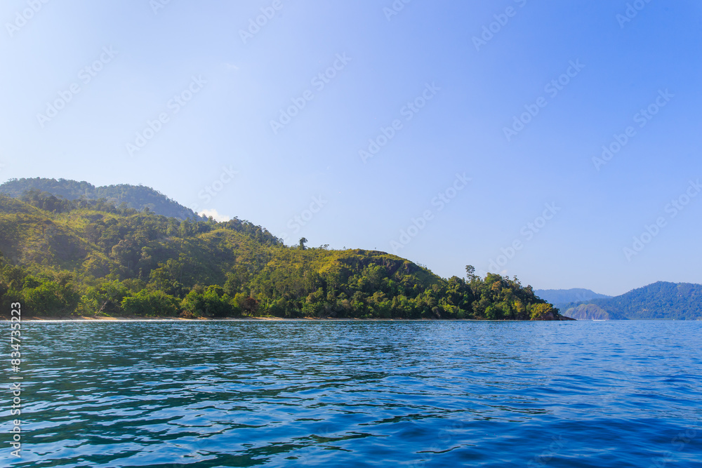 Serene Tropical Escape: Lush Green Islands Rising from Tranquil Blue Waters Under a Clear Sky ; ocean at padang, west sumatra ; indonesia tourism Serene Tropical Escape: Lush Green Islands Rising from Tranquil Blue Waters Under a Clear Sky ; ocean at padang, west sumatra ; indonesia tourism
