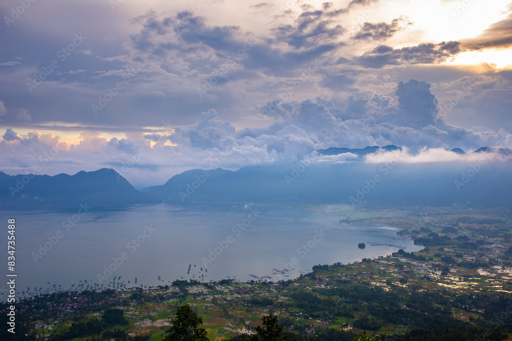 Expansive Panorama of Danau Maninjau at Sunset, Lush Mountains Embrace the Quiet Wate ; indonesia tourism Expansive Panorama of Danau Maninjau at Sunset, Lush Mountains Embrace the Quiet Wate ; indonesia tourism