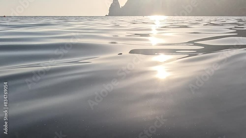Sea water surface. Low angle view over clear azure sea water. Sun glare. Abstract nautical summer ocean nature. Holiday, vacation and travel concept. Nobody. Slow motion. Weather and climate change photo