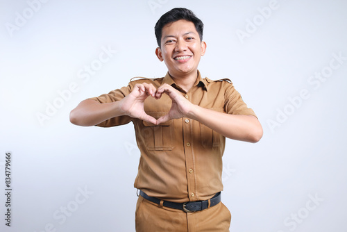 Young Government Worker in A Brown Uniform And Making Love Symbol With Fingers. Pegawai Negeri Sipil Of Indonesia or PNS. photo