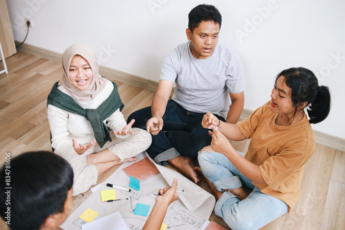 Group Of Diverse Teenage Friends Sitting On The Floor Doing School Work Together © Gatot