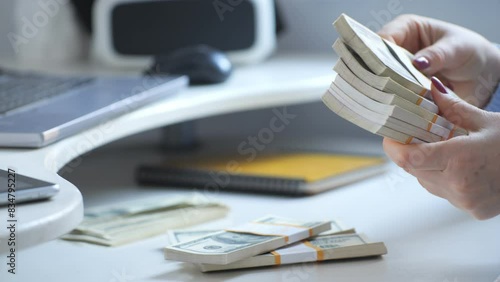 Closeup shot of hands counting stacks of 100dollar bills in an office, related to finance and business sectors photo