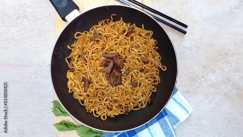 Mie goreng usus are placed in a frying pan. Fried noodles with the addition of sweetly spiced intestines. Indonesian food. photo