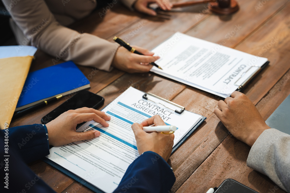 justice and law concept. team judge in a courtroom the gavel, working with digital tablet computer on wood table in sun light.