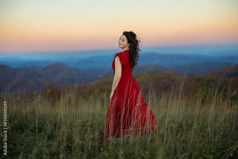 Woman standing in a field gazing far away Woman standing in a field gazing far away