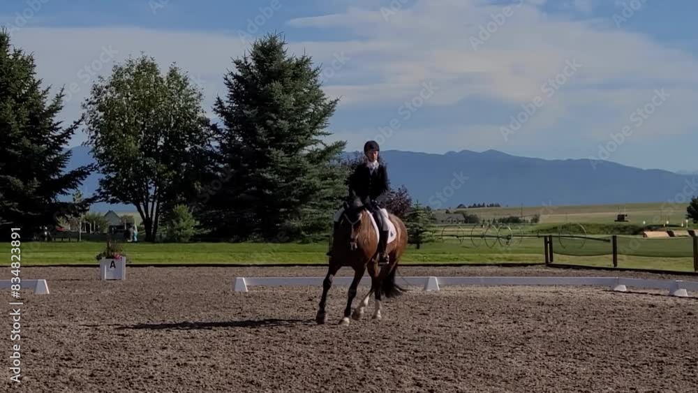 A young lady horseback riding in a dressage horse show in Montana with Glacier National Park in the background. A young lady horseback riding in a dressage horse show in Montana with Glacier National Park in the background.