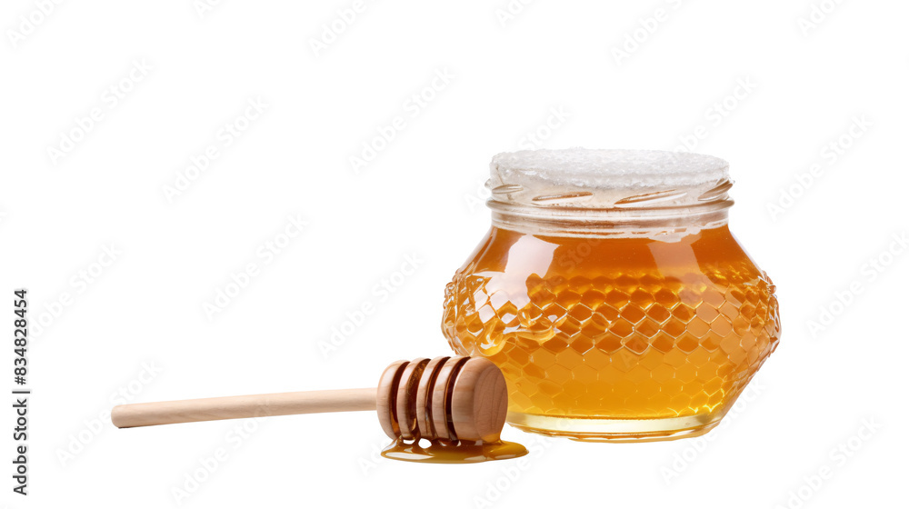 a jar of honey next to a wooden stick a jar of honey next to a wooden stick