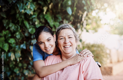 Retirement  senior woman hugging nurse in portrait for assisted living for person with disability and medical care. Healthcare and women with wheelchair for help  support and rehabilitation in garden