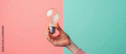 A human hand holding a pseudobulb against a solid color backdrop with copy space photo