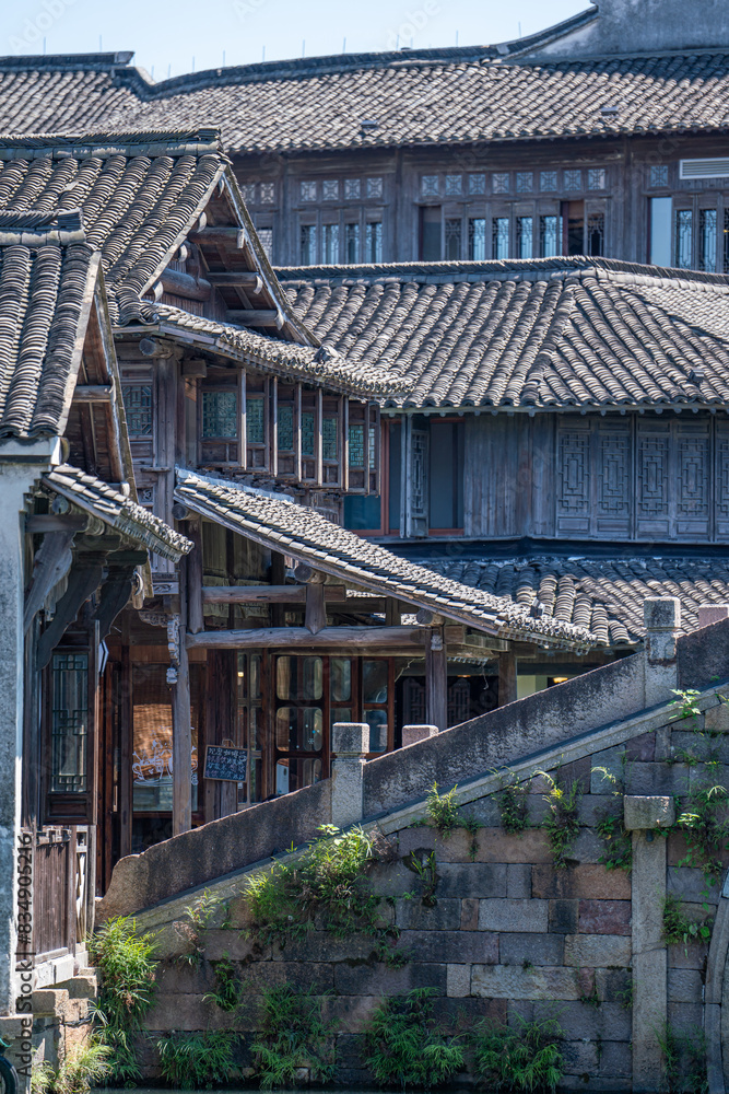 Obraz premium Discover China Wuzhen's ancient architecture, where old stone paths and bridges reflect on peaceful waters. Experience the charm of historic buildings along serene rivers..