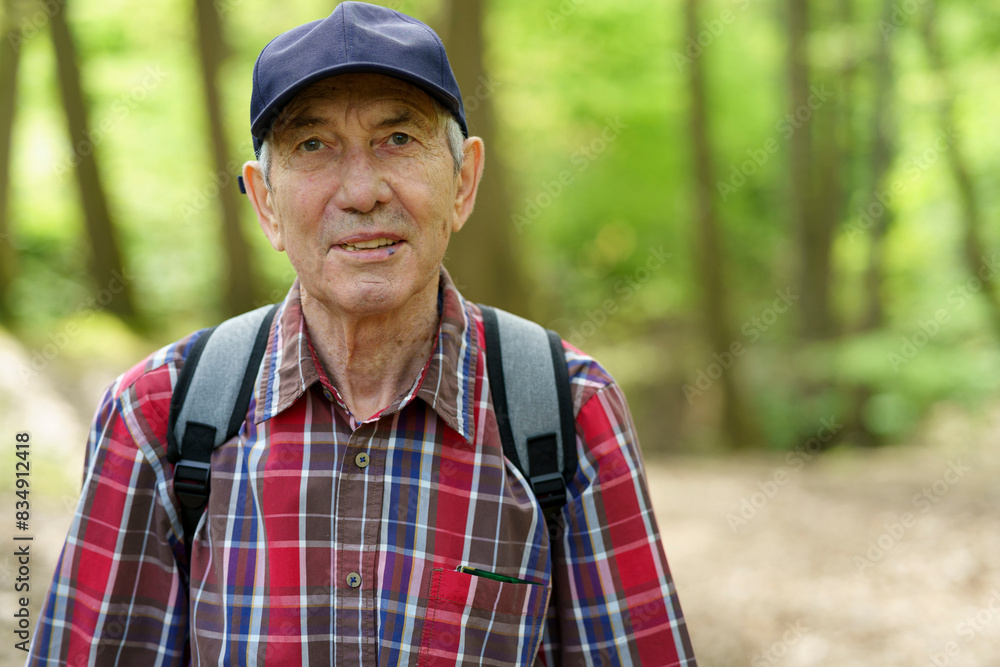 Portrait of an elderly man in a cap and plaid shirt in the forest Portrait of an elderly man in a cap and plaid shirt in the forest