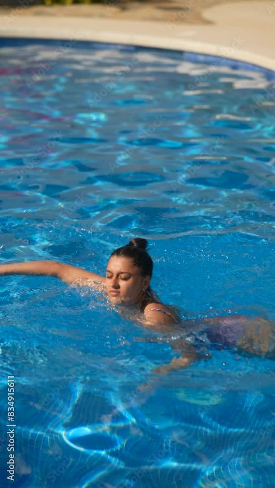 Woman swimming in sunny outdoor pool, enjoying blue water for exercise and relaxation Woman swimming in sunny outdoor pool, enjoying blue water for exercise and relaxation