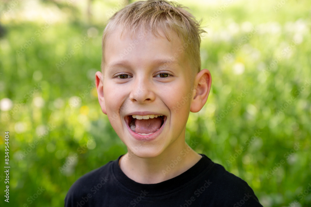 Portrait of a broadly smiling boy against a background of green grass. Portrait of a broadly smiling boy against a background of green grass.
