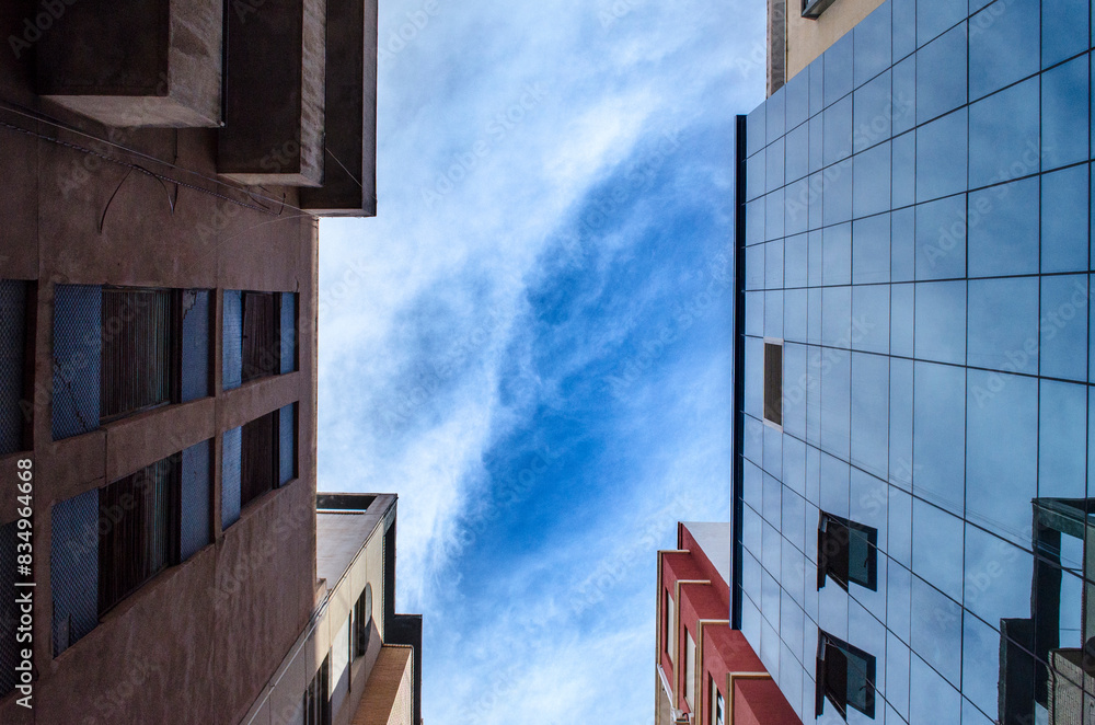Obraz premium office building opposite of an old building with a cloudy sky