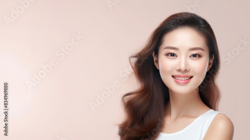 Beautiful Asian woman model with a radiant smile against a soft pink background