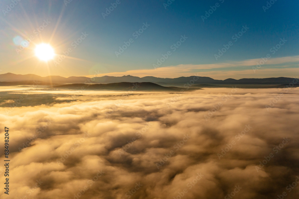 Fototapeta premium Drone flies over fluffy clouds before sunset. Photo above clouds, sense of wonder and admiration.