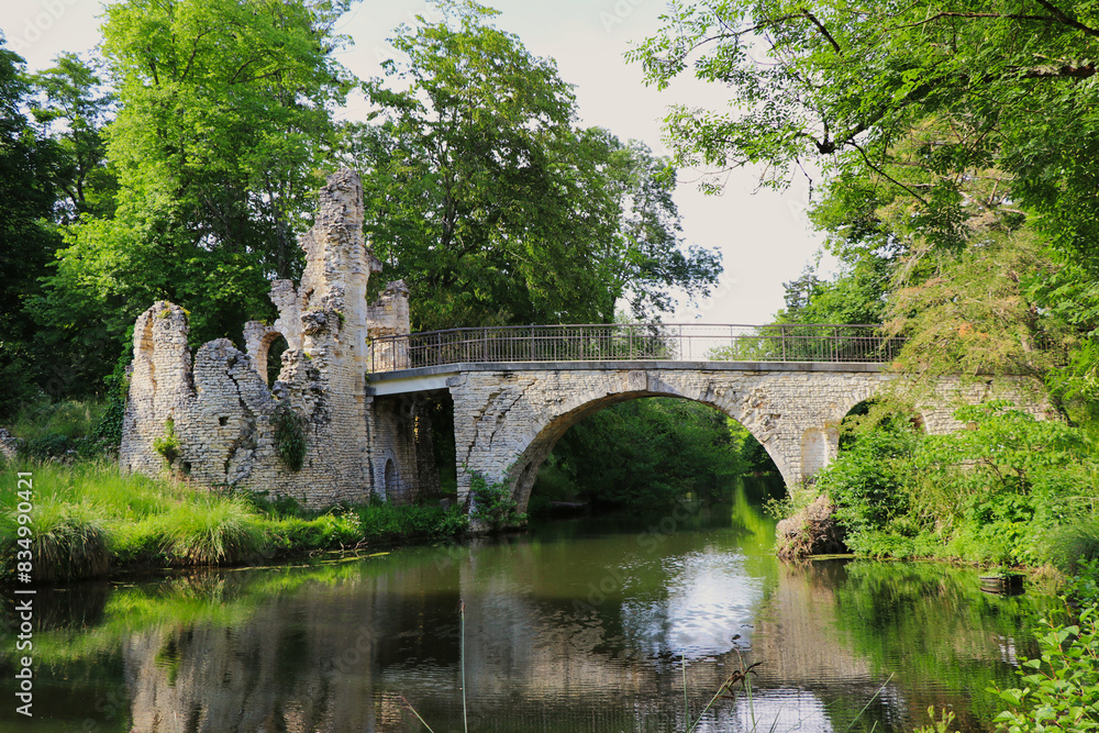 an ancient stone bridge and ruins over a tranquil river, surrounded by lush green trees. The scene combines historical charm with natural beauty, evoking a peaceful ambiance. an ancient stone bridge and ruins over a tranquil river, surrounded by lush green trees. The scene combines historical charm with natural beauty, evoking a peaceful ambiance.