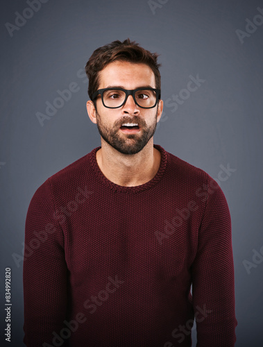 Studio, glasses and man with funny face, eye care and wellness with frame, portrait and lens for vision. Gray background, healthy and product for person, prescription and eyewear with fashion in USA