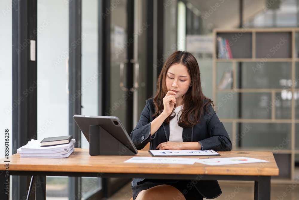 Asian business woman working on a tablet. Asian business woman working on a tablet.