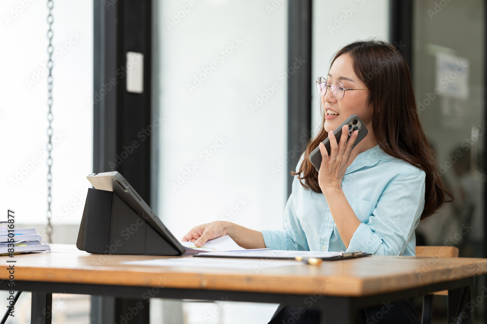 Asian woman talking on smartphone with customer Business matters Asian woman talking on smartphone with customer Business matters