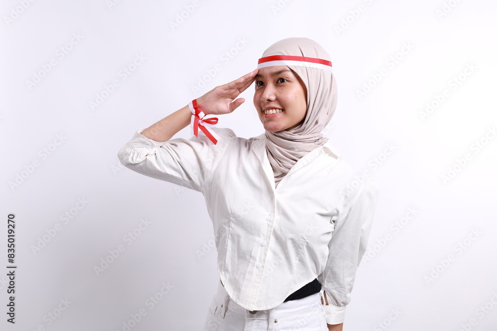Beautiful veiled Asian muslim woman giving salute celebrate Indonesian independence day on August 17 isolated over white background