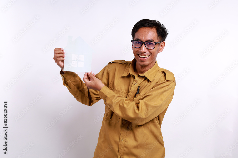 Portrait of Happy government worker or pegawai negeri sipil or pns wearing khaki uniform standing while holding home paper craft Portrait of Happy government worker or pegawai negeri sipil or pns wearing khaki uniform standing while holding home paper craft