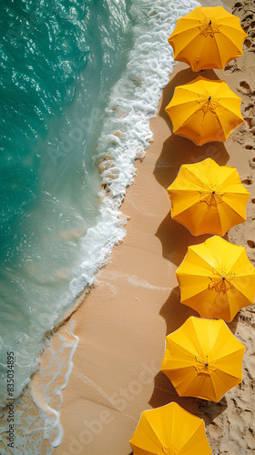 Top view of a yellow beach umbrellas lined up on sandy shore by the turquoise ocean. Minimal summer concept. photo