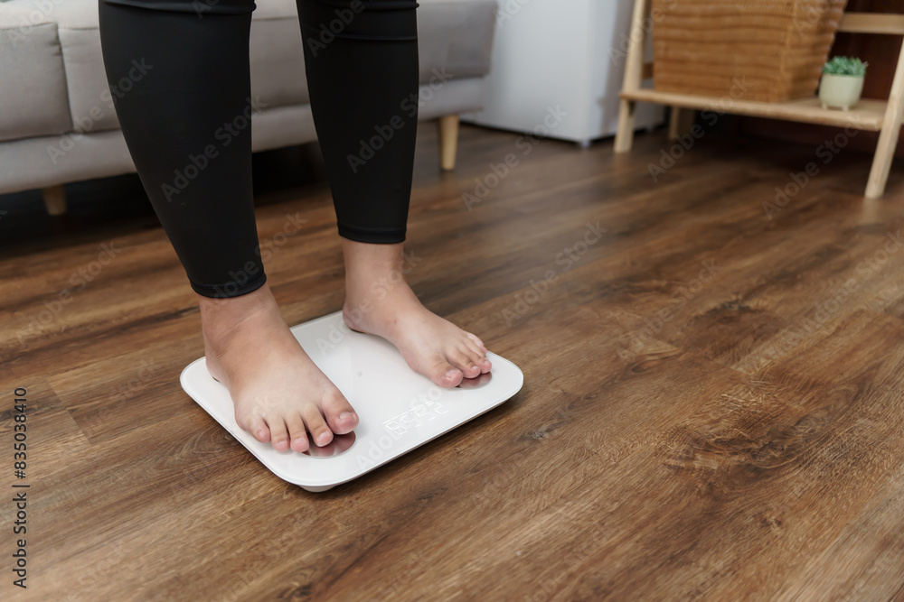 Fat diet and scale feet standing on electronic scales for weight control. Measurement instrument in kilogram for a diet control. Fat diet and scale feet standing on electronic scales for weight control. Measurement instrument in kilogram for a diet control.