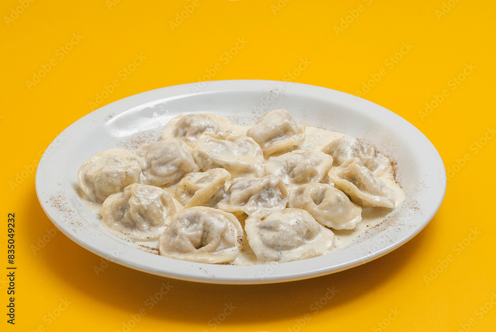 boiled dumplings on a white plate on a yellow background boiled dumplings on a white plate on a yellow background