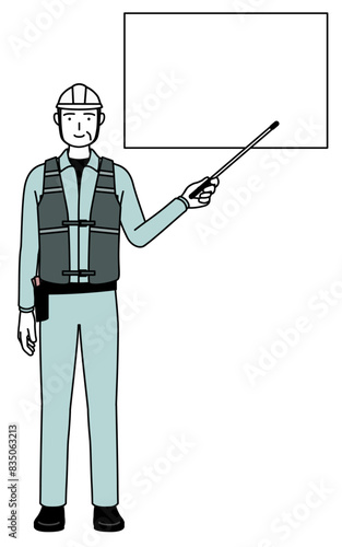 Senior male engineer in helmet and work wear pointing at a whiteboard with an indicator stick.