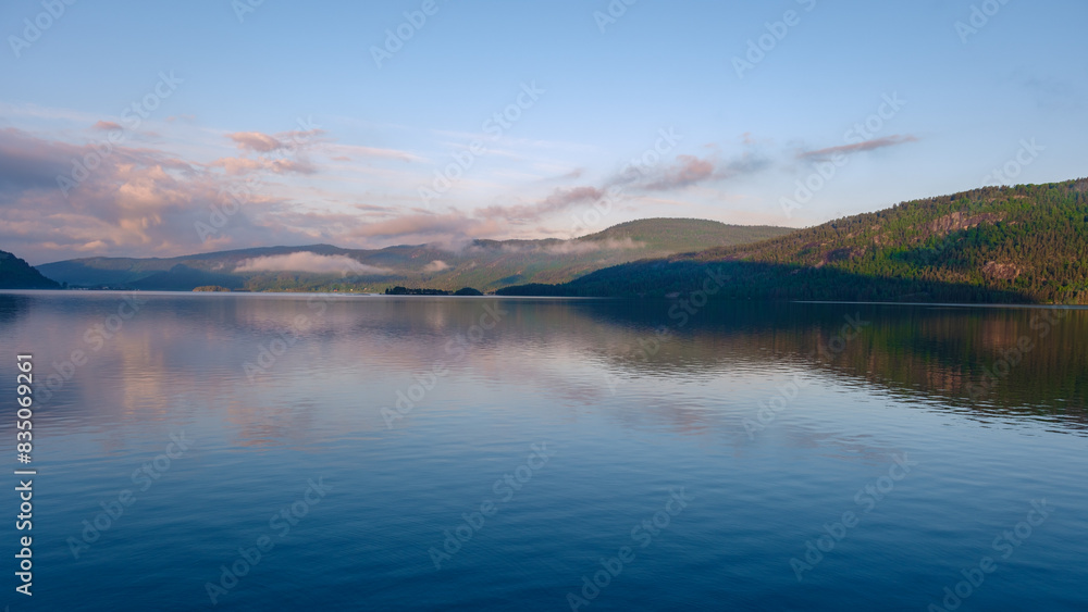 Byglandsfjord Lake in Norway is, a beautiful mountain lake at sunrise with reflections in the lake Byglandsfjord Lake in Norway is, a beautiful mountain lake at sunrise with reflections in the lake