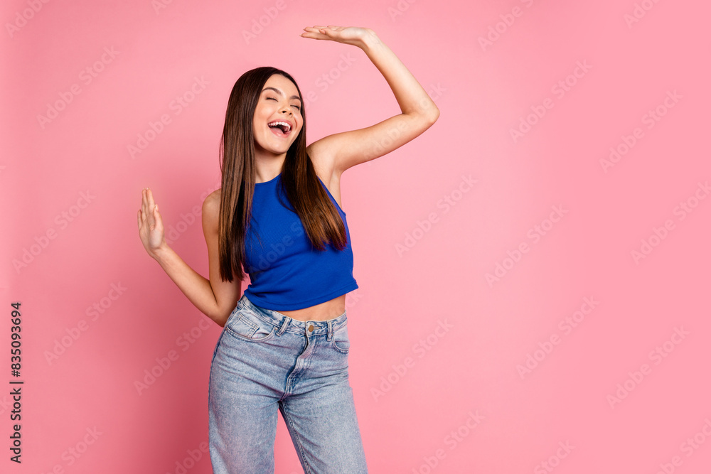 Photo of charming dreamy girl wear blue top dancing empty space isolated pink color background Photo of charming dreamy girl wear blue top dancing empty space isolated pink color background