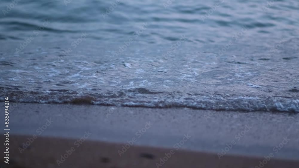 Evening seashore with wave close up. Calm night ocean water waves splashing sandy beach. Closeup sea waves breaking sand beach at summer morning. slow motion. nature background travel relax. no people Evening seashore with wave close up. Calm night ocean water waves splashing sandy beach. Closeup sea waves breaking sand beach at summer morning. slow motion. nature background travel relax. no people