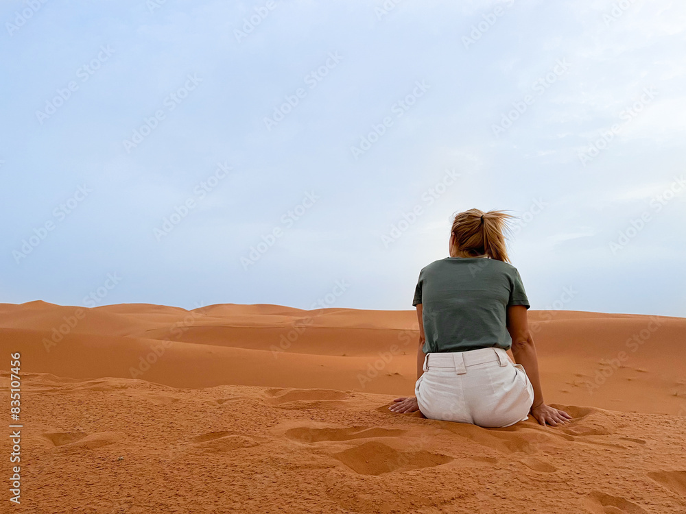 Serenity in the Sands: Woman Contemplating the Desert Horizon at Merzouga, Morocco Serenity in the Sands: Woman Contemplating the Desert Horizon at Merzouga, Morocco