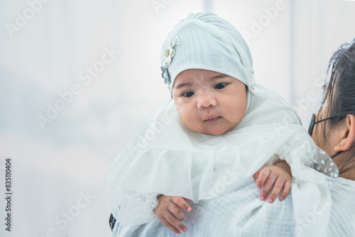 Muslim family, an Asian mother holding baby newborn girl is 2-month-old. standing on white background. to Muslim family and infant newborn concept.
