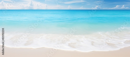 White sandy beach with crystal clear tropical waters and waves  ideal for a relaxing vacation  perfect for a copy space image.