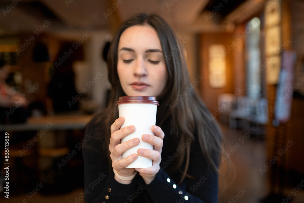 Young woman enjoying a coffee, hands in focus. Young woman enjoying a coffee, hands in focus.