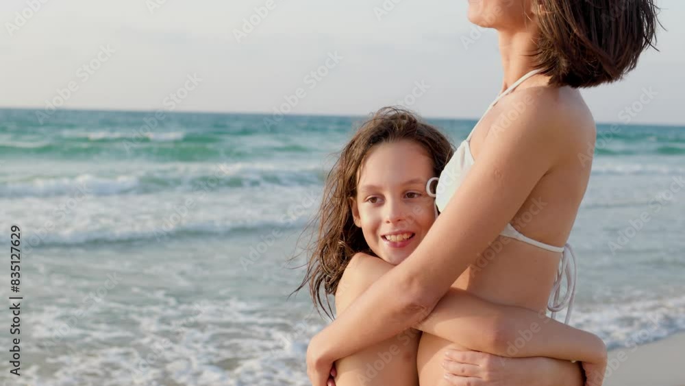 Summer day on the beach. Happy young mother hugging her son on the beach, family laughing and having fun together. young mother with a child. Family holiday at sea. Summer day on the beach. Happy young mother hugging her son on the beach, family laughing and having fun together. young mother with a child. Family holiday at sea.