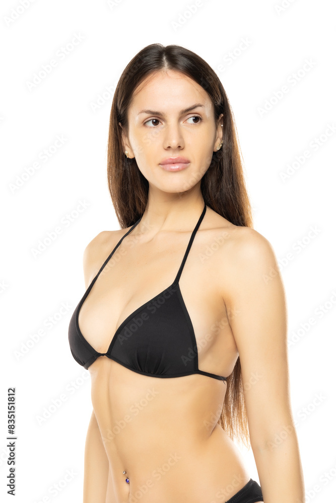 Obraz premium Young brunette woman in bikini bra swimsuit posing on a white studio background. Front view