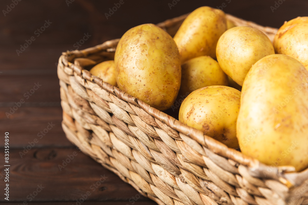 Young potatoes. Fresh potatoes in wooden crate on a wooden background.Harvesting collection. organic, freshly dug potatoes. Agricultural background. Vegan. Vegetables.Place for text.Copy space Young potatoes. Fresh potatoes in wooden crate on a wooden background.Harvesting collection. organic, freshly dug potatoes. Agricultural background. Vegan. Vegetables.Place for text.Copy space