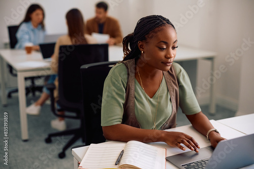Young black entrepreneur working on her laptop in shared office space.