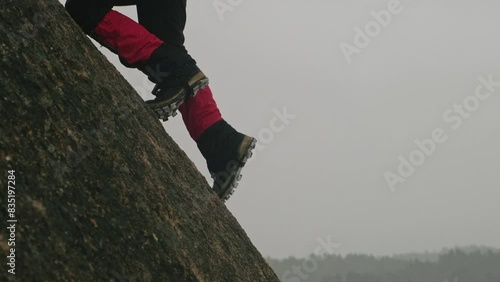 Person Ascending A Rocky Outcrop On A Foggy Day