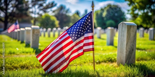 Closeup of an American flag fluttering beside a grave in a cemetery on Memorial Day or Independence Day , American flag, USA, graveyard, Memorial Day, Independence Day, patriotism