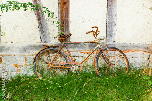 Altes rostiges Fahrrad an der Wand eines alten Fachwerkhauses photo