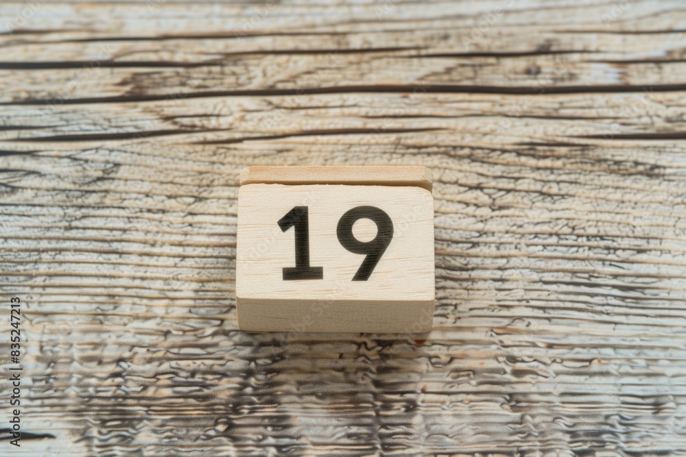 A wooden block with the number 19 engraved on it A wooden block with the number 19 engraved on it